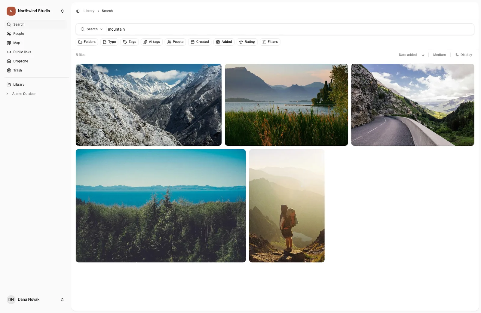 OLO search results for “mountain”: five photos of peaks, a mountain road, a lake below a ridge and a hiker above a valley.